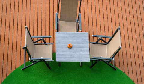 Patio furniture on green artificial turf, seen from above