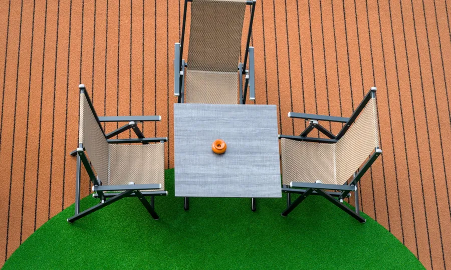 Patio furniture on green artificial turf, seen from above