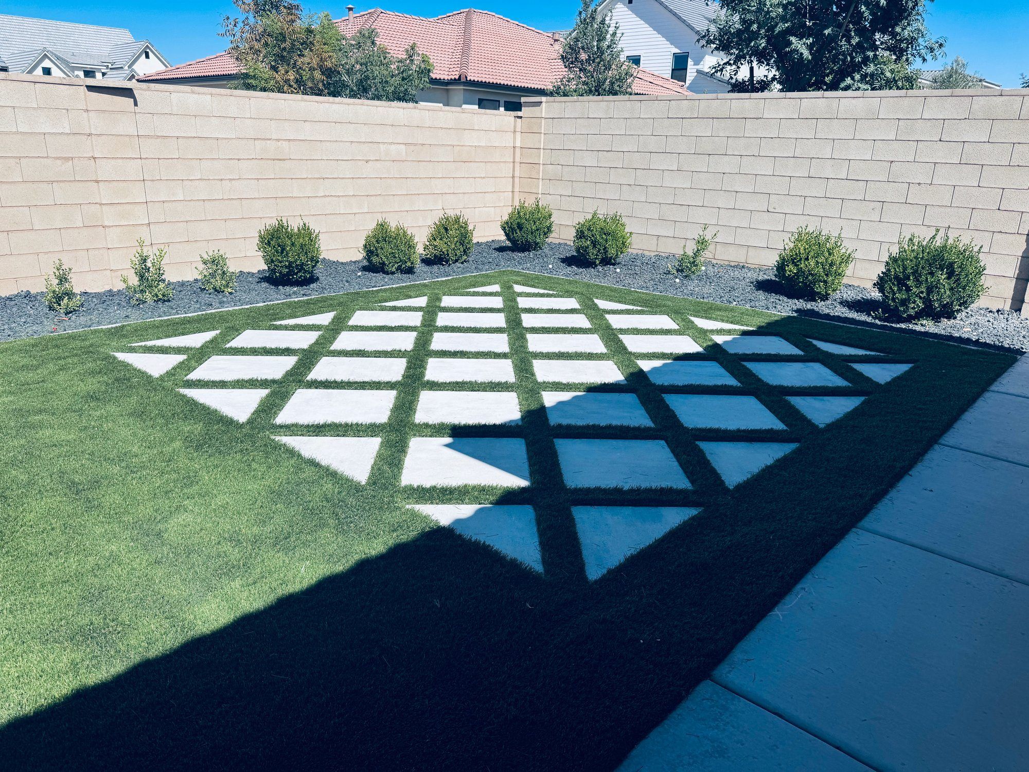 Diamond-pattern pavers and artificial turf in a St. George backyard